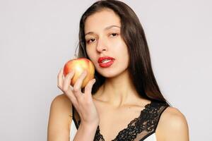 sano comiendo. mujer mordiendo rojo manzana con Perfecto dientes foto