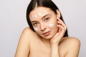 portrait of a laughing woman applying face cream photo