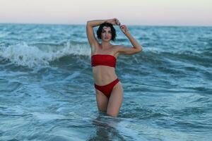 sexy espalda de un hermosa mujer en rojo bikini en mar antecedentes foto