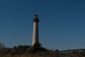 esta es capa mayo punto faro visto desde el playa. el alto blanco estructura con rojo metal sirve como un Faro de seguridad. foto