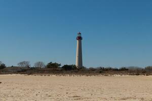 esta es capa mayo punto faro visto desde el playa. el alto blanco estructura con rojo metal sirve como un Faro de seguridad. foto