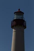 This is the top image of Capy May point lighthouse. The red metal top stands out against the white brick of the tower. photo