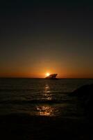 Sunset beach in Cape May New Jersey where you can get a great view of the sun going down across the ocean and the bay. The reflection of the sun on the water with the sunken ship looks so beautiful. photo