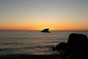 puesta de sol playa en capa mayo nuevo jersey dónde usted lata obtener un genial ver de el Dom yendo abajo a través de el Oceano y el bahía. el reflexión de el Dom en el agua con el hundido Embarcacion mira entonces hermosa. foto