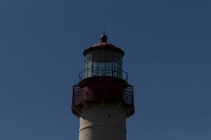 This is the top image of Capy May point lighthouse. The red metal top stands out against the white brick of the tower. photo