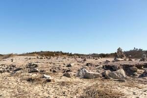 This rocky beach was at Sunset Beach in Cape May New Jersey. This beach is iconic for all the pebbles and rocks that are on it. The sand dunes in the back really add to this image. photo