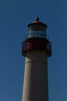 This is the top image of Capy May point lighthouse. The red metal top stands out against the white brick of the tower. photo