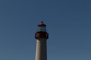 This is the top image of Capy May point lighthouse. The red metal top stands out against the white brick of the tower. photo