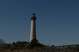 esta es capa mayo punto faro visto desde el playa. el alto blanco estructura con rojo metal sirve como un Faro de seguridad. foto