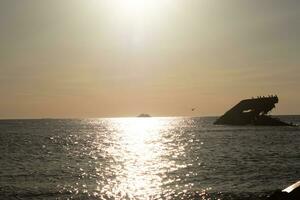 puesta de sol playa en capa mayo nuevo jersey dónde usted lata obtener un genial ver de el Dom yendo abajo a través de el Oceano y el bahía. el reflexión de el Dom en el agua con el hundido Embarcacion mira entonces hermosa. foto