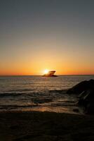 Sunset beach in Cape May New Jersey where you can get a great view of the sun going down across the ocean and the bay. The reflection of the sun on the water with the sunken ship looks so beautiful. photo