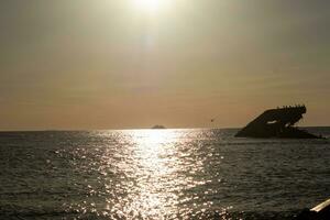 puesta de sol playa en capa mayo nuevo jersey dónde usted lata obtener un genial ver de el Dom yendo abajo a través de el Oceano y el bahía. el reflexión de el Dom en el agua con el hundido Embarcacion mira entonces hermosa. foto