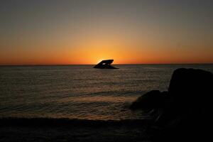 puesta de sol playa en capa mayo nuevo jersey dónde usted lata obtener un genial ver de el Dom yendo abajo a través de el Oceano y el bahía. el reflexión de el Dom en el agua con el hundido Embarcacion mira entonces hermosa. foto