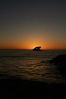 Sunset beach in Cape May New Jersey where you can get a great view of the sun going down across the ocean and the bay. The reflection of the sun on the water with the sunken ship looks so beautiful. photo