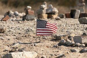 This beautiful American flag was in this sand monument that was created on the beach. I loved the look of this blowing in the wind with all the stones stacked up around it. Seemed very patriotic. photo