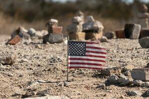 This beautiful American flag was in this sand monument that was created on the beach. I loved the look of this blowing in the wind with all the stones stacked up around it. Seemed very patriotic. photo