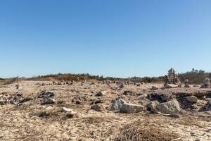 This rocky beach was at Sunset Beach in Cape May New Jersey. This beach is iconic for all the pebbles and rocks that are on it. The sand dunes in the back really add to this image. photo
