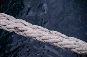 a rope is tied to a boat in the ocean photo