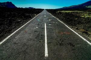 an empty road in the middle of a desert photo