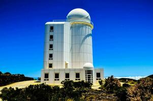 a white dome on top of a hill with a blue sky photo