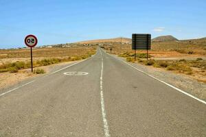 an empty road in the middle of a desert photo