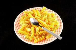 a plate of pasta with a spoon on top photo
