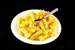 a plate of pasta with a spoon on top photo