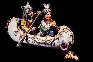 a figurine of two native american men in a canoe photo