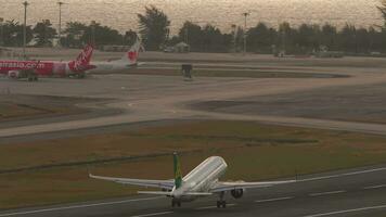 PHUKET, THAILAND FEBRUARY 19, 2023 Airbus A320 of Spring Airlines take off at Phuket airport. Flight departure. Aircraft climbing. Beautiful shot, Airplane takes off over the sea, sun glare video