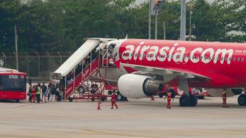 phuket, thailand februari 27, 2023 människor styrelse ett flygplan. flygplan på de flygfält, trappa. lågpris av airasia. resa begrepp video