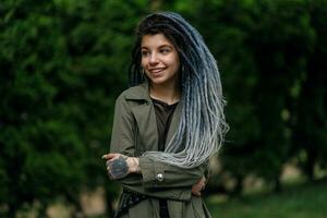 cheerful caucasian girl looking at the camera and smiling model with dreadlocks photo