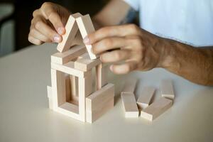 Business man placing wooden block on a tower concept risk control photo