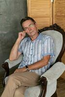 An old intelligent man having a rest on a armchair photo