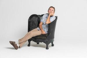 Senior sitting in an armchair and pensive, dreamy photo