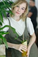 Close up young cheerful woman in dress happily looking in camera photo