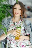 Close up young cheerful woman in dress happily looking in camera photo