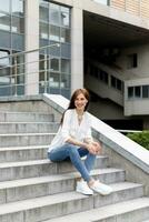 Attractive young woman in the city. Business lady standing near business center photo