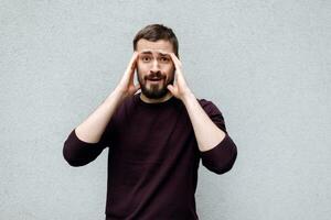 Studio portrait of surprised excited blond mature man wearing jumper photo