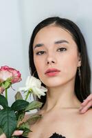 young beautiful woman smelling a bunch of red roses photo