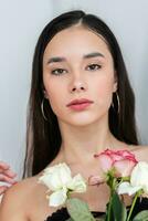 young beautiful woman smelling a bunch of red roses photo