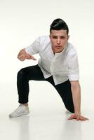 Handsome, young, trendy man is sitting on the floor in studio photo