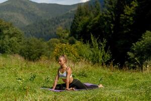 Fitness woman sitting in a yoga pose in a park. photo