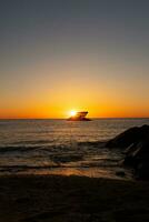 Sunset beach in Cape May New Jersey where you can get a great view of the sun going down across the ocean and the bay. The reflection of the sun on the water with the sunken ship looks so beautiful. photo