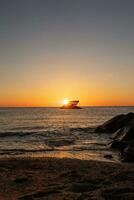 Sunset beach in Cape May New Jersey where you can get a great view of the sun going down across the ocean and the bay. The reflection of the sun on the water with the sunken ship looks so beautiful. photo