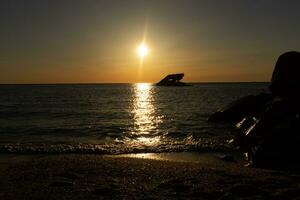 puesta de sol playa en capa mayo nuevo jersey dónde usted lata obtener un genial ver de el Dom yendo abajo a través de el Oceano y el bahía. el reflexión de el Dom en el agua con el hundido Embarcacion mira entonces hermosa. foto