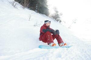 snowboarder se sienta alto en el montañas foto