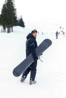 snowboarder en casco en pie a el muy parte superior de un montaña foto