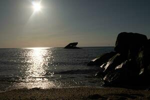 puesta de sol playa en capa mayo nuevo jersey dónde usted lata obtener un genial ver de el Dom yendo abajo a través de el Oceano y el bahía. el reflexión de el Dom en el agua con el hundido Embarcacion mira entonces hermosa. foto