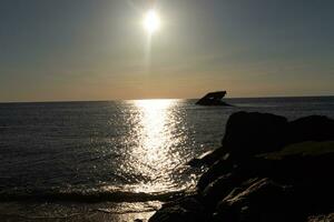 puesta de sol playa en capa mayo nuevo jersey dónde usted lata obtener un genial ver de el Dom yendo abajo a través de el Oceano y el bahía. el reflexión de el Dom en el agua con el hundido Embarcacion mira entonces hermosa. foto