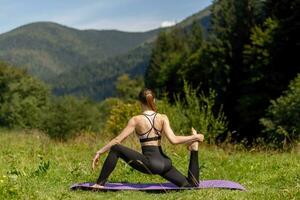 Fitness woman sitting in a yoga pose in a park. photo